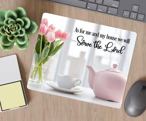 Desk setup with a mouse pad featuring a tea set and flowers, and text 'As for me and my house we will serve the Lord'.