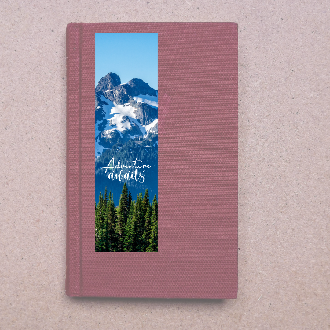 Pink book with a mountain and forest cover on a beige background