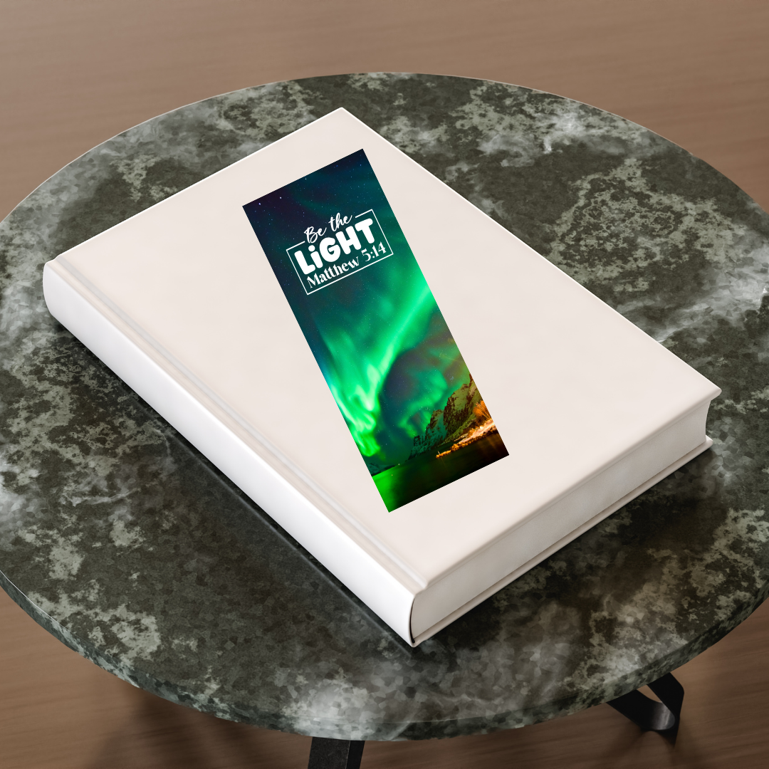Book with a digital display showing an aurora borealis scene and text on a marble table.