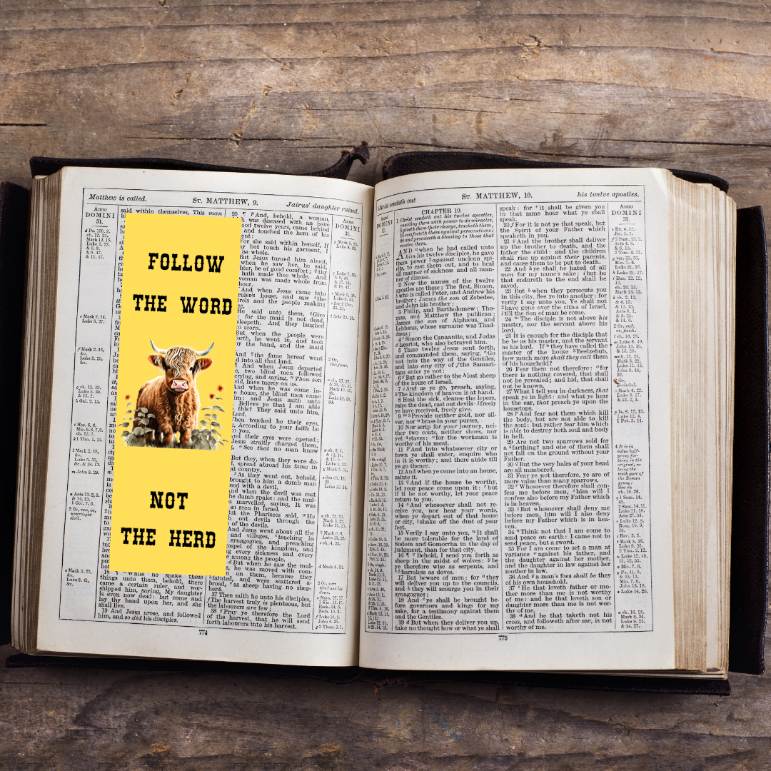 Open book with a yellow sticker featuring a cow and text on a wooden surface