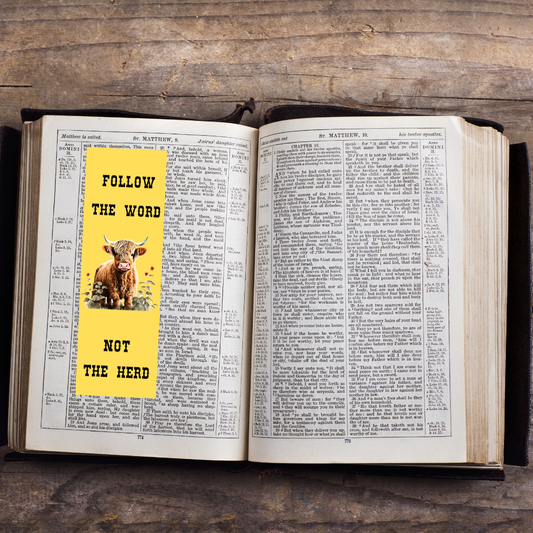 Open book with a yellow sticker featuring a cow and text on a wooden surface
