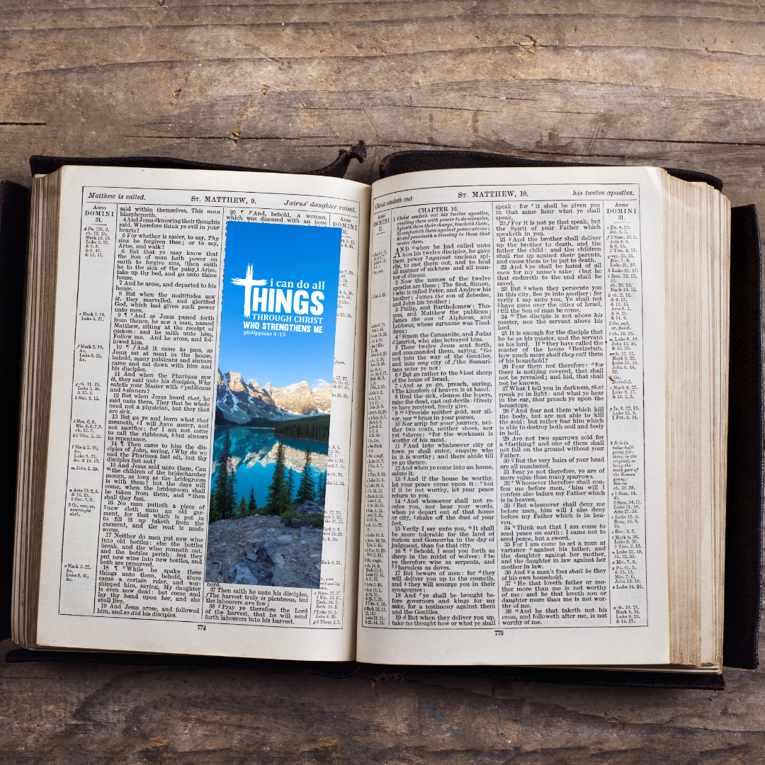 Open book with a scenic image and 'I can do all things' text overlay on a wooden surface