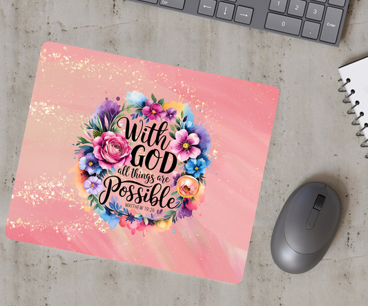Pink mouse pad with floral design and motivational quote on a desk with keyboard and mouse.